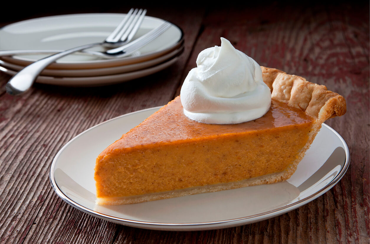 Slice of Pumpkin Pie Topped With a Piping of Whipped Cream
